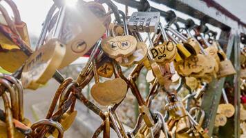 Sunlit love locks on a bridge railing symbolizing romance and commitment, ideal for themes like Valentines Day and relationship bonds photo
