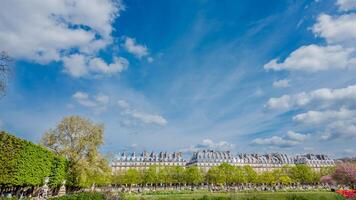 Spectacular view of Parisian architecture and public gardens under a vibrant blue sky with wispy clouds, perfect for travel and spring season themes photo