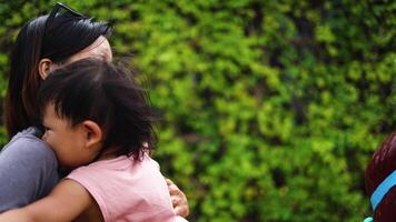 Mother hugs her son while walking in the garden. video