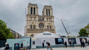 Visitors exploring the renovation exhibition in front of Notre Dame Cathedral under a gloomy sky in Paris, France, on April 14th, 2024, related to architecture and history photo