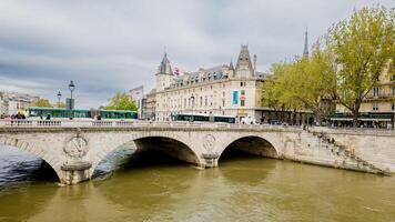 Springtime view of the Seine River and historic stone bridge against a cloudy sky in Paris, France, on April 14th, 2024a great capture for travel and architecture themes photo