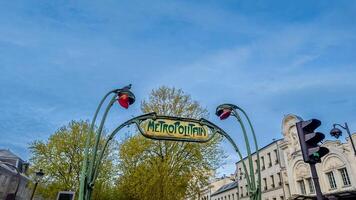 icónico Arte Nouveau parisino metropolitano firmar con primavera follaje, claro azul cielo en París, Francia, capturado en abril 14, 2024, ideal para viaje y historia temas foto