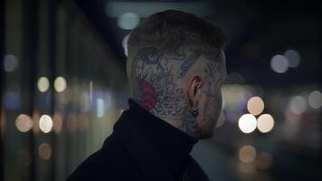 pouco convencional jovem homem coberto dentro tatuagens e Sombrio Preto roupas video
