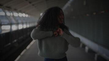 gelukkig jong vrouw met gekruld haar- dansen Aan stad straat in langzaam beweging video