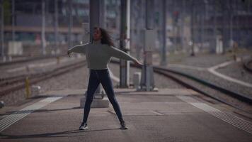 gelukkig jong vrouw met gekruld haar- dansen Aan stad straat in langzaam beweging video