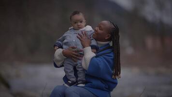 mãe segurando jovem bebê criança Garoto lado de fora desfrutando família vida video