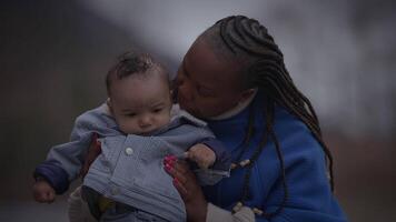 mãe segurando jovem bebê criança Garoto lado de fora desfrutando família vida video
