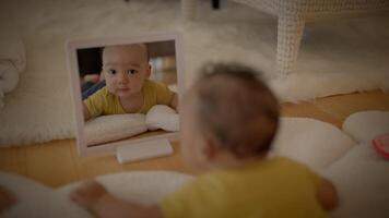 joven bebé infantil mirando dentro espejo acecho él mismo video