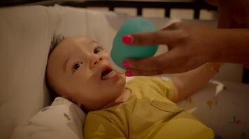 Mother Feeding Young Baby Infant Child Lying in Crib at Home video