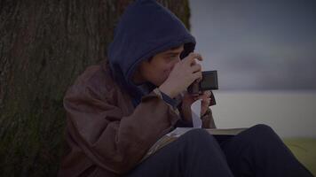 jovem homem levando uma cenário com velho vintage Câmera lado de fora video