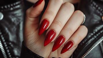Detailed close up of a stylish woman s hand with a vibrant red nail polish manicure photo