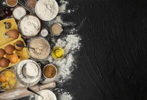 Baking ingredients for dough on black background photo