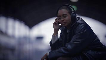 urbano estilo de vida retrato de relajado hembra persona con auriculares jugando sonido video