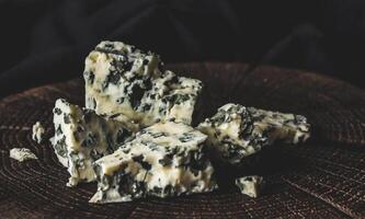 Danish blue cheese on black wooden background, with copy space photo