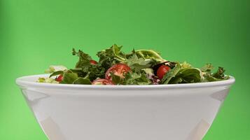Fresh salad in bowl on green background photo