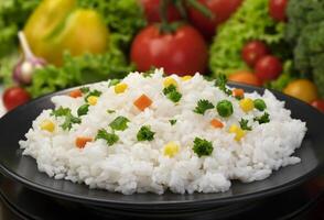 cocido arroz papilla, servido con hierbas y vegetales foto