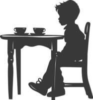 Silhouette little boy sitting at a table in the cafe black color only vector