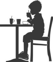 silueta pequeño chico sentado a un mesa en el café negro color solamente vector