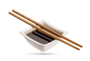 Bowl of soy sauce and chopsticks isolated on white photo