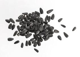 Heap of black sunflower seeds isolated on white photo