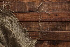 Old hessian texture on wooden table, top view photo