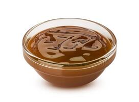 Caramel sauce in small glass bowl isolated on white background photo