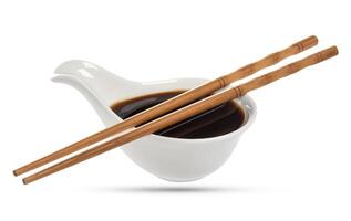 Soy sauce and chopsticks isolated on white photo