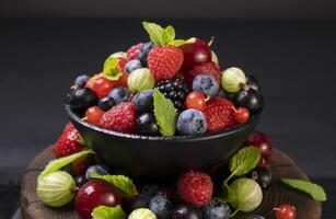 Mix of wild berries on black background photo