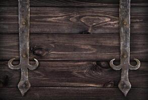 Forged metal elements on dark wooden doors photo