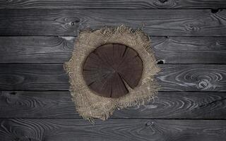 Round cutting board on black wooden table photo