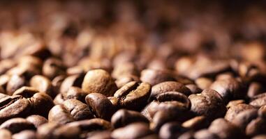 Pile of coffee beans texture, close up, dark background, shallow depth of field photo
