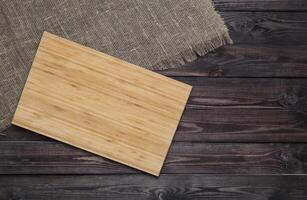 Empty cutting board on dark wooden planks photo