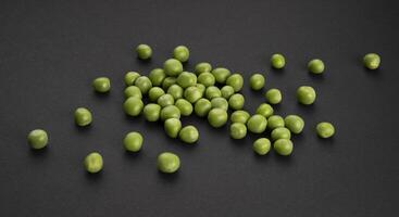 Pile of green peas on black background photo