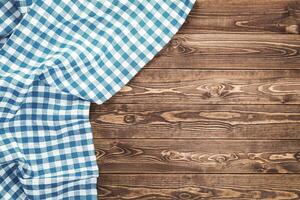 Blue checkered tablecloth on wooden table photo