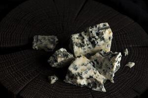 Danish blue cheese on black wooden background, with copy space photo