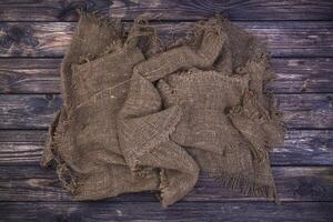 Burlap on black wooden background, top view photo