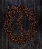 café símbolo hecho de asado café frijoles en un negro de madera antecedentes foto
