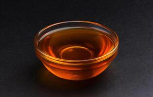 Bowl of honey on black background photo