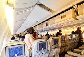 Medina, Saudi Arabia on March 3, 2024. Umrah pilgrims board a Saudi Arabia Airlines plane to return to their home country, Indonesia. Plane to Jakarta. Passengers look for their seats. photo