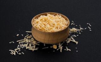 Grated parmesan cheese on black background photo