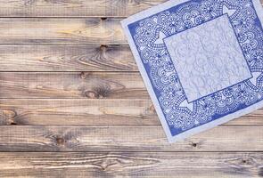 Blue napkin on wooden table, top view photo