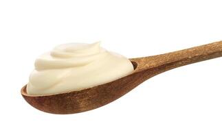 Sour cream in spoon isolated on white background photo