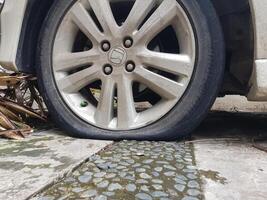 Jakarta, Indonesia in August 2019. A punctured and deflated honda jazz tire was hit by a nail. photo