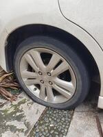 Jakarta, Indonesia in August 2019. A punctured and deflated honda jazz tire was hit by a nail. photo