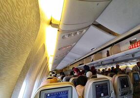 Medina, Saudi Arabia on March 3, 2024. Umrah pilgrims board a Saudi Arabia Airlines plane to return to their home country, Indonesia. Plane to Jakarta. Passengers look for their seats. photo