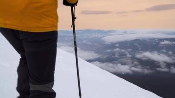 une voyageur des promenades sur une neigeux pente dans le montagnes dans l'hiver. le concept de Voyage et actif mode de vie. 4k video