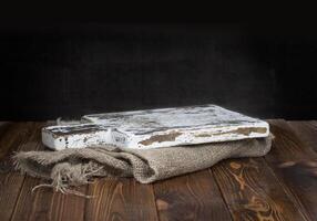 Old wooden chopping board with burlap tablecloth photo