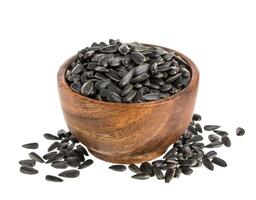 Black sunflower seeds in bowl isolated on white photo