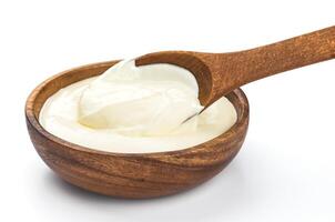 Sour cream in wooden bowl isolated on white photo