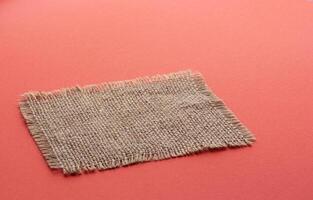 Burlap napkin on red color background photo